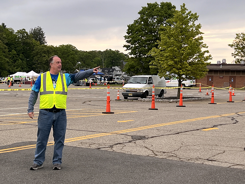 Volunteer directs cars in parking lot at Lake Hopatcong Block Party
