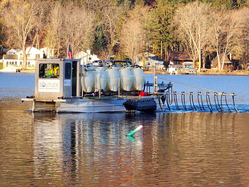 A barge delivers an alum treatment on lake