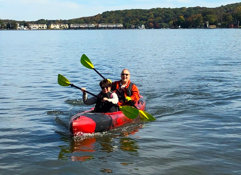 Two people paddle a tandem kayak on Lake Hopatcong.  Bertrand Island is in the background.