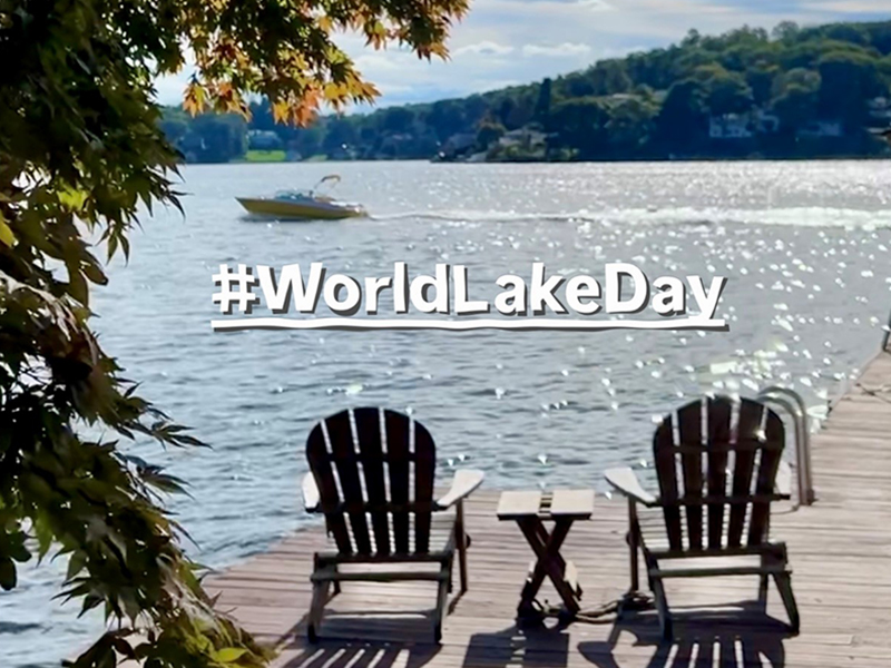 A Lake with Adirondack chairs and a boat